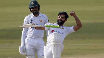 Pakistan's Fawad Alam, right, celebrates after scoring century while his teammate Faheem Ashraf watches during the second day of the first cricket test match between Pakistan and South Africa at the National Stadium, in Karachi, Pakistan, Wednesday, Jan. 27