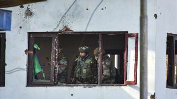 Army personnel conduct searches in the house where militants were hiding, after an encounter with th