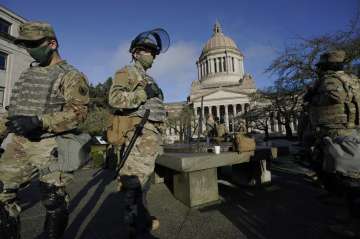 Members of the Washington National Guard stand at a sundial near the Legislative Building