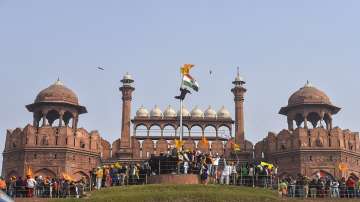 Farmers hoist flags at the Red Fort during the tractor rally amid the 72nd Republic Day celebrations, in New Delhi.