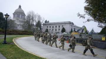 Washington National Guard members walk in formation away from the Legislative Building.
