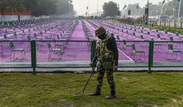 A security person inspects a lawn as preparations underway near the India Gate for the upcoming Repu