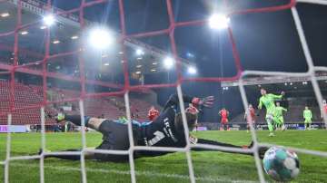 Wolfsburg's Wout Weghorst, background right, scores on a penalty shot past Union Berlin's goalkeeper Andreas Luthe during a German Bundesliga soccer match between Union Berlin and Wolfsburg, at the Stadion An der Alten Försterei, in Berlin, Saturday, Jan. 9