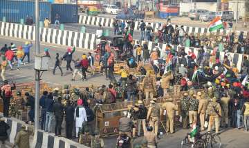 Farmers break the police barricades at the Ghazipur border as move towards Akshardham during their t