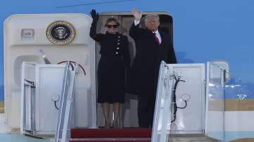 President Donald Trump and first lady Melania Trump wave to a crowd as they board Air Force One at Andrews Air Force Base.