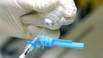 A medical worker holding a vaccine and a syringe.
