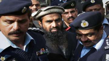 Pakistani police officers escort Zaki-ur-Rehman Lakhvi, center, the main suspect of the Mumbai terror attacks in 2008, after his court appearance in Islamabad, Pakistan. Pakistan's security forces arrested Saturday, Jan. 2, 2021 an alleged leader of the militant group that was behind the bloody 2008 Mumbai attacks in India.