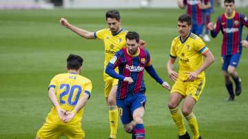 Barcelona's Lionel Messi, center, controls the ball during the Spanish La Liga soccer match between FC Barcelona and Cadiz at the Camp Nou stadium in Barcelona, Spain, Sunday, Feb. 21