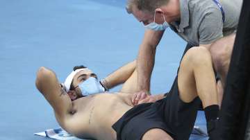 Italy's Matteo Berrettini, left, receives medical treatment during a break while playing Russia's Karen Khachanov during their third round match at the Australian Open tennis championships in Melbourne, Australia, Saturday, Feb. 13