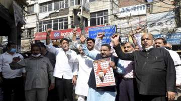 Members of the Confederation of All India Traders (CAIT) shout slogans during a protest against several alleged draconian and arbitrary amendments in GST by flouting the fundamental rights of the traders, at Chawri Bazar, in New Delhi.