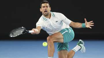 Serbia's Novak Djokovic hits a forehand return to Canada's Milos Raonic during their fourth round match at the Australian Open tennis championship in Melbourne, Australia, Sunday, Feb. 14