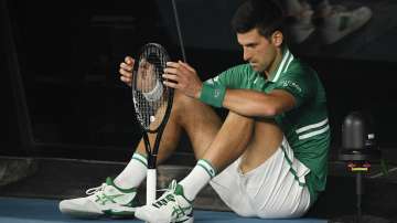 Serbia's Novak Djokovic sits down at the back of the court between games during his quarterfinal against Germany's Alexander Zverev at the Australian Open tennis championship in Melbourne, Australia, Tuesday, Feb. 16