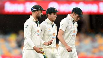 Tim Paine, Nathan Lyon and Pat Cummins of Australia are seen leaving the field