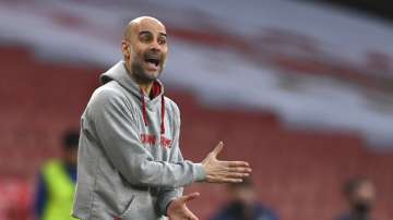Manchester City's head coach Pep Guardiola reacts during the English Premier League soccer match between Arsenal and Manchester City at the Emirates stadium in London, England, Sunday, Feb. 21