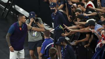 Australia's Nick Kyrgios gives his racquet to fans after defeating France's Ugo Humbert during their second round match at the Australian Open tennis championship in Melbourne, Australia, Wednesday, Feb. 10