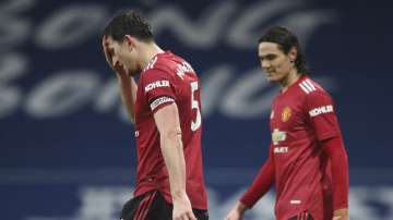 Manchester United's Harry Maguire, left, and Manchester United's Edinson Cavani react during the English Premier League soccer match between West Bromwich Albion and Manchester United at the Hawthorns stadium in West Bromwich, England, Sunday, Feb. 14