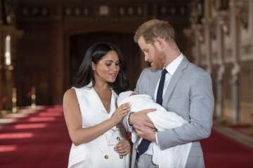 FILE - In this Wednesday May 8, 2019 file photo, Britain's Prince Harry and Meghan, Duchess of Sussex, pose during a photocall with their newborn son Archie, in St George's Hall at Windsor Castle, Windsor, south England. One of the most dramatic claims in Prince Harry and Meghan's interview with Oprah Winfrey was that their son was denied a royal title, possibly because of the color of his skin. Queen Elizabeth II has nine great-grandchildren, including Archie. They are not princes and princesses, apart from the three children of Prince William, who is second in line to the throne and destined to be king one day. 
 