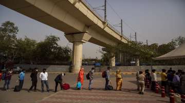 Passengers wait for their turn to be tested for COVID-19 at a bus terminal in New Delhi.