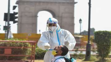 A health worker collects swab sample from a person for COVID-19 test, at the India Gate in New Delhi.