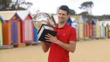 Serbia's Novak Djokovic poses for photos with the Norman Brookes Challenge Cup at Brighton Beach after defeating Russia's Daniil Medvedev on Sunday Feb. 21, 2021 in the men's singles final at the Australian Open tennis championship in Melbourne, Australia, Monday, Feb. 22
