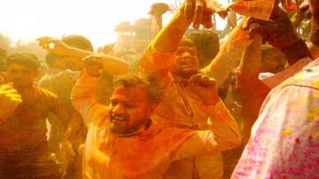 Hindu devotees dance as colored powder is thrown on them at Ladali, or Radha temple, at the legendary hometown of Radha, consort of Hindu God Krishna, during Lathmar holi, in Barsana, 115 kilometers (71 miles) from New Delhi.