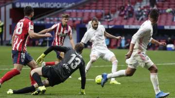 Real Madrid's Karim Benzema scores his side's opening goal during the Spanish La Liga soccer match between Atletico Madrid and Real Madrid at the Wanda Metropolitano stadium in Madrid, Spain, Sunday, March 7