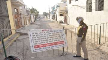 A police constable stands guard outside a containment zone after some residents tested positive with COVID-19, in Patiala.