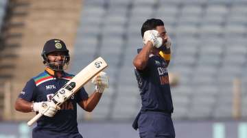 India batsman Rishabh Pant looks on as KL Rahul celebrates reaching his century by putting his gloves to his ears during the 2nd One Day International between India and England at MCA Stadium on March 26