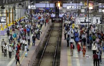 Commuters wait to board suburban trains at Chhatrapati Shivaji Maharaj Terminus prior to the night curfew that has been introduced to curb the spread of Coronavirus in Mumbai, Maharashtra