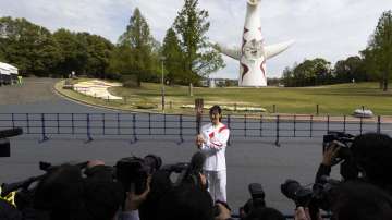 Former Olympian Aya Terakawa, participating as an Olympic torch relay runner, poses for the media before she carries the torch during the first day of the Osaka round at a former Expo site in Suita, north of Osaka, western Japan, Tuesday, April 13