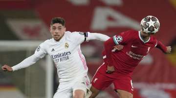 Liverpool's Thiago, right, is challenged by Real Madrid's Federico Valverde during a Champions League quarter final second leg soccer match between Liverpool and Real Madrid at Anfield stadium in Liverpool, England, Wednesday, April 14