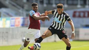 Newcastle's Joelinton, right, battles for the ball with West Ham's Ben Johnson during the English Premier League soccer match between Newcastle United and West Ham United at St James' Park, Newcastle, England, Saturday April 17