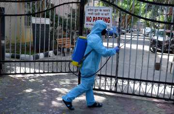 A worker sanitises an area outside a residential complex as a precautionary measure against COVID-19, in Mumbai