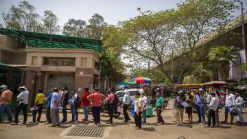 People wait for their turn to be tested for COVID-19 at a government hospital in Noida, a suburb of New Delhi.