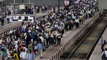 Commuters wait to board a suburban train at Chhatrapati Shivaji Maharaj Terminus prior to the night curfew that has been introduced to curb the spread of Coronavirus in Mumbai.
