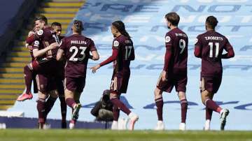 Leeds United's Stuart Dallas, left, is congratulated by teammates after scoring his team's first goal during the English Premier League soccer match between Manchester City and Leeds United at Etihad Stadium, Manchester, England, Saturday April 10
