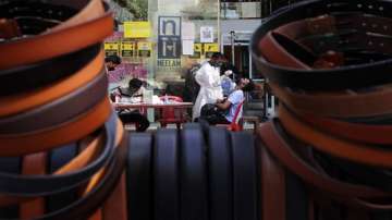 A health worker takes a swab sample to test for COVID-19 outside shopping mall in Mumbai.