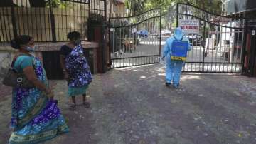 A civic worker sanitizes the gates of a residential building in Mumbai, India.