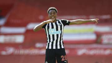 Newcastle's Joe Willock celebrates after scoring his side's opening goal during the English Premier League soccer match between Liverpool and Newcastle United at Anfield stadium in Liverpool, England, Saturday, April 24