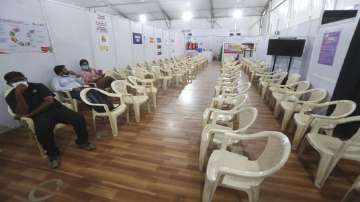 Health workers sit in the waiting area of vaccination center.?