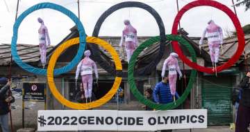 In this Feb. 3, 2021, file photo, exile Tibetans use the Olympic Rings as a prop as they hold a street protest against the holding of the 2022 Beijing Winter Olympics, in Dharmsala