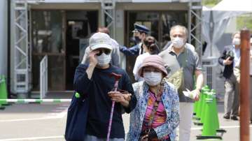 Elderly people go out of the newly-opened mass vaccination center after receiving the Moderna coronavirus vaccine in Tokyo, Monday, May 24