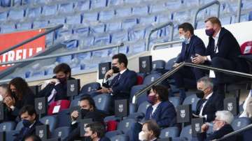 Barcelona's head coach Ronald Koeman, top right, watches from stands during the Spanish La Liga soccer match between FC Barcelona and Atletico Madrid at the Camp Nou stadium in Barcelona, Spain, Saturday, May 8