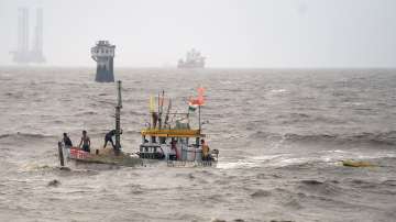 Fishermen on a fishing boat try to recover their smaller boat which had drifted away due to rough sea condition.