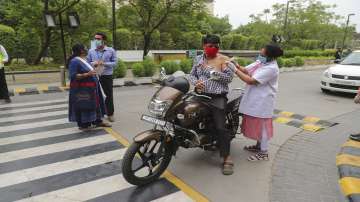 A man on a motorcycle gets inoculated against COVID-19 during a drive in vaccination facility for people above 45 years at a shopping mall in Noida, outskirts of New Delhi.