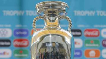 In this Sunday, April 25, 2021 file photo, journalists are reflected in the Euro 2020 soccer tournament trophy at the National Arena stadium, a tournament venue, in Bucharest, Romania.