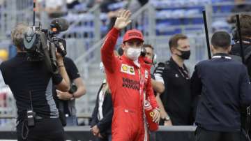 Ferrari driver Charles Leclerc of Monaco, center, waves after the qualifying session at the Monaco racetrack, in Monaco, Saturday, May 22