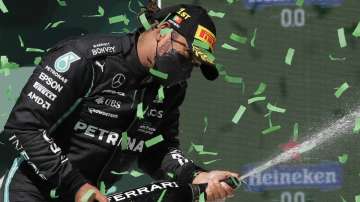 Mercedes driver Lewis Hamilton of Britain celebrates on the podium after winning the Portugal Formula One Grand Prix at the Algarve International Circuit near Portimao, Portugal, Sunday, May 2