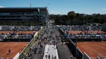 Visitors stroll in the alleys of the Roland Garros stadium during the French Open tennis tournament, Sunday, May 30, 2021