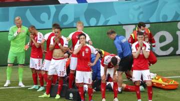 Denmark players react while medics assist their teammate Christian Eriksen 